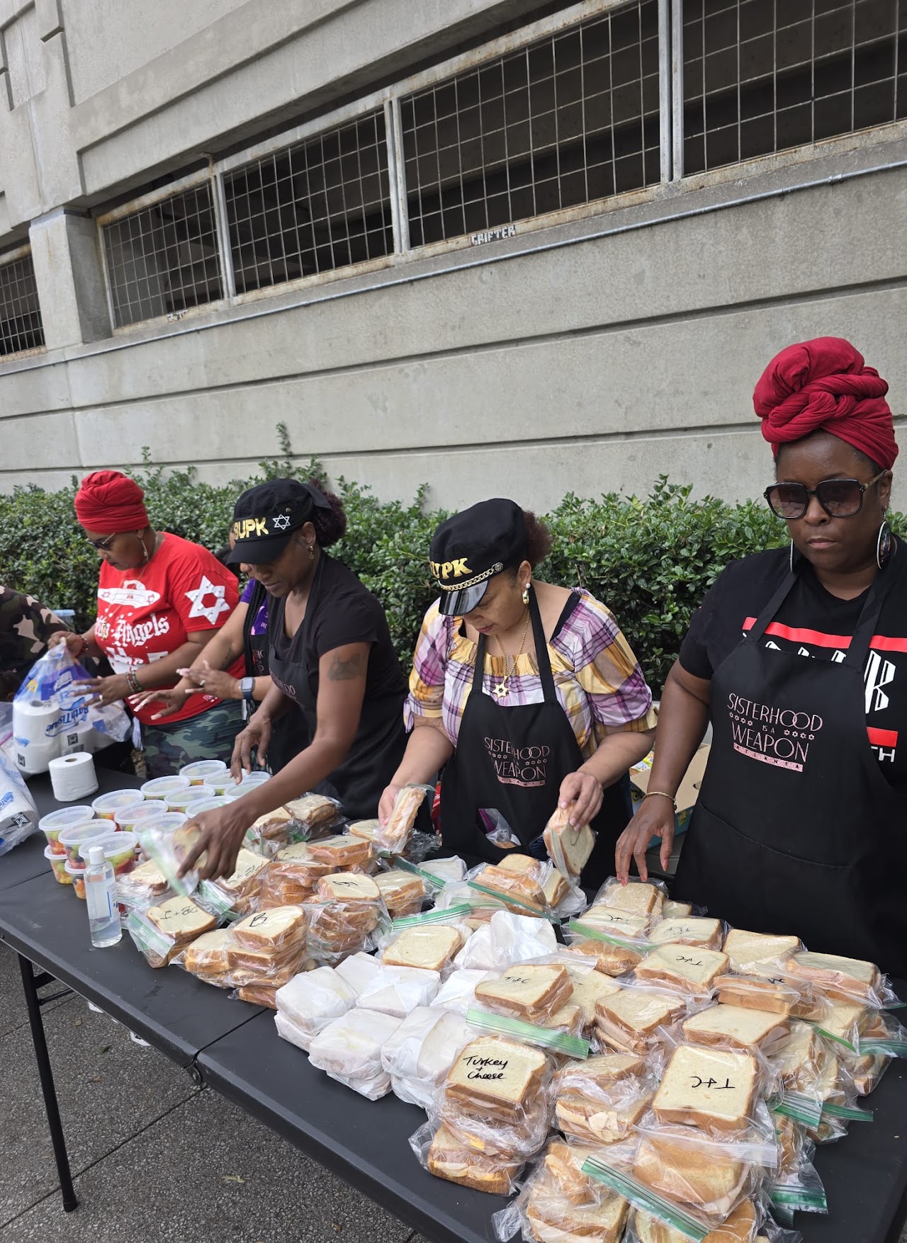 Volunteers assembling meals at outdoor tables